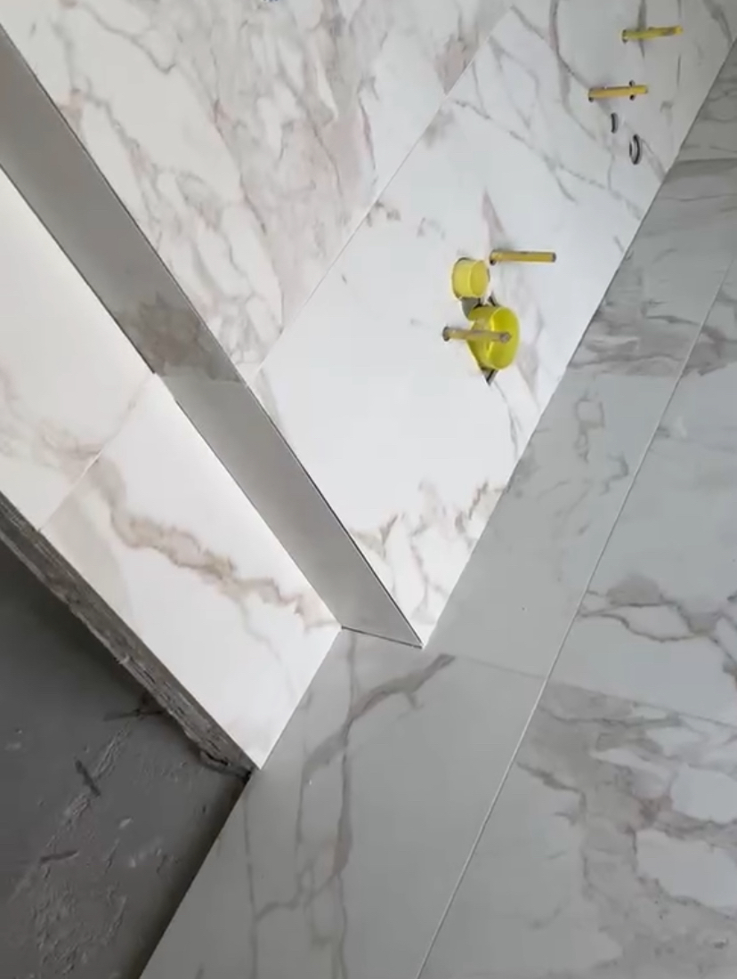 fehér márvány csempe felragasztva felrögzitve a falra, burkolás és csempézés Budapesten
